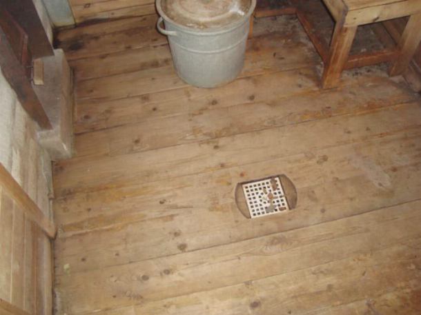 Сливная решетка на деревянном полу